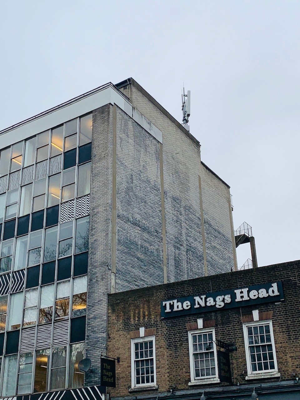 side view of the e-1 studies building with The Nags Head signage