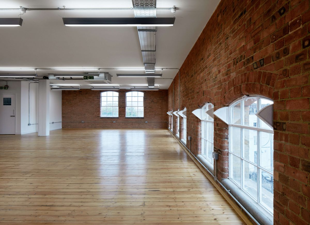 open plan office area light wooden flooring floor level windows