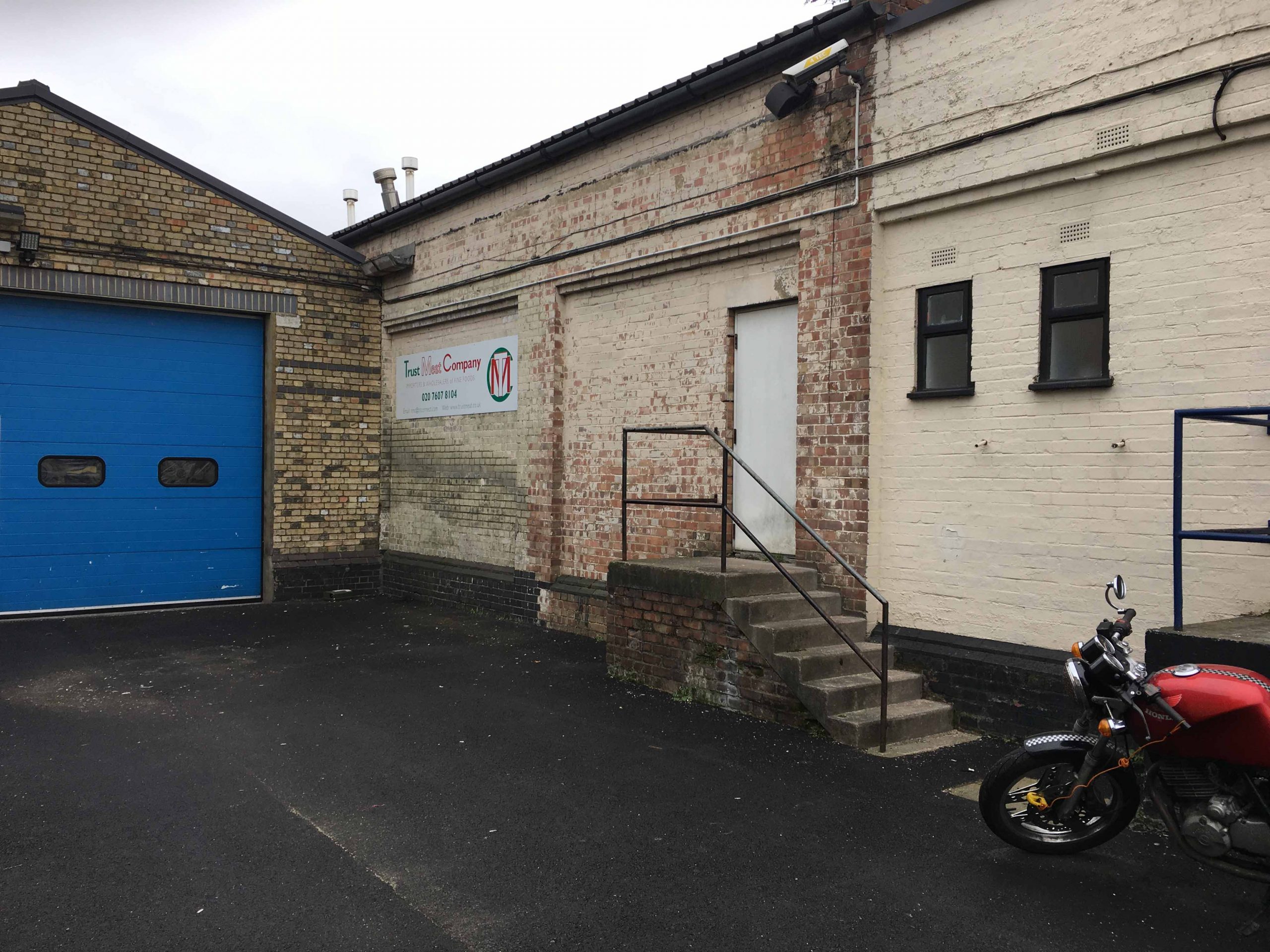 outside view of a storage building with stairs and blue garage-like doors