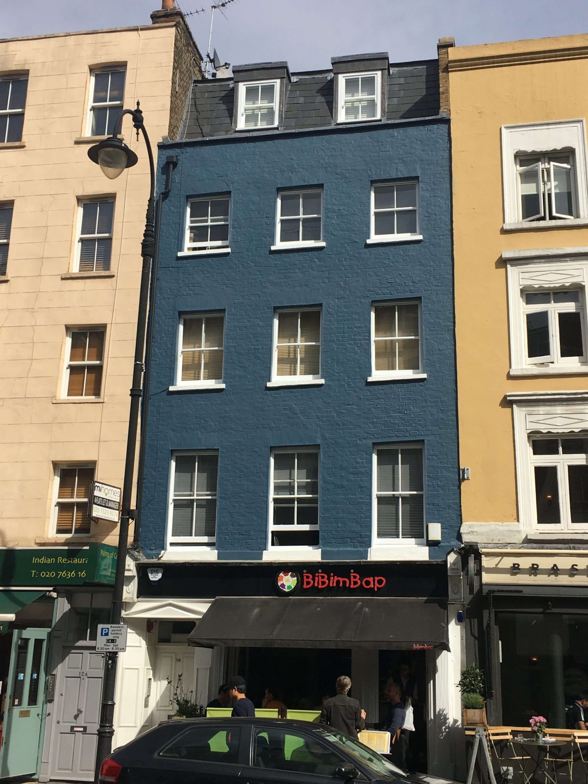 blue painted town house on top of a shop