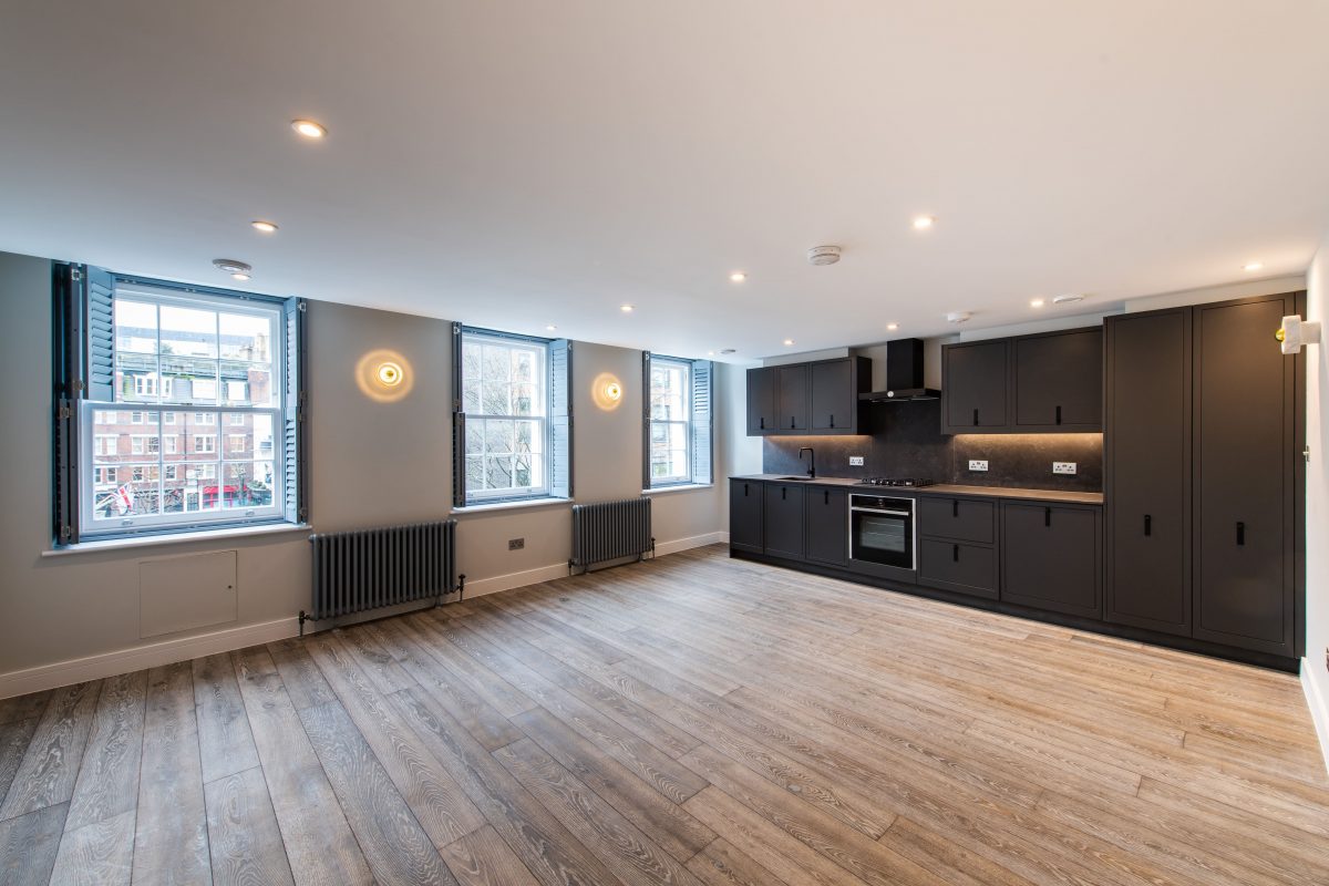 modern dark grey slab kitchen large open plan room with three large window and black radiators