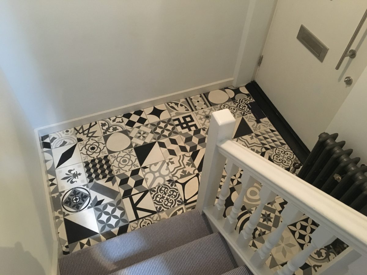 white and black pattern tiled floor at the bottom of some stairs